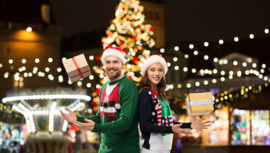 happy couple with gifts at christmas market