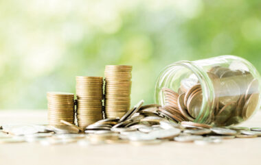 Coin on wooden table in front of green bokeh background.