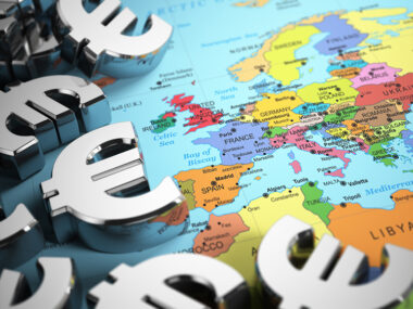 Euro sign on the world map background with DOF effect.